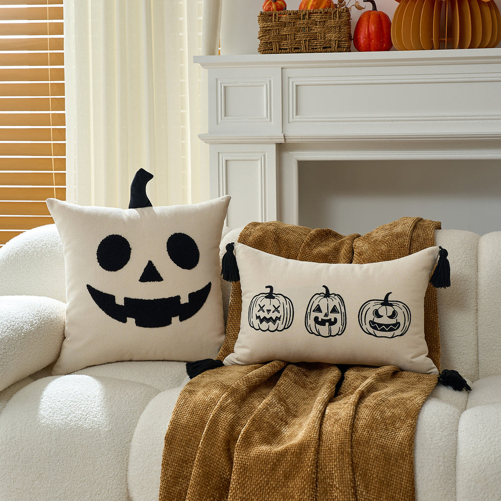 Pumpkin face and ghost cushion covers on a sofa with autumn styling