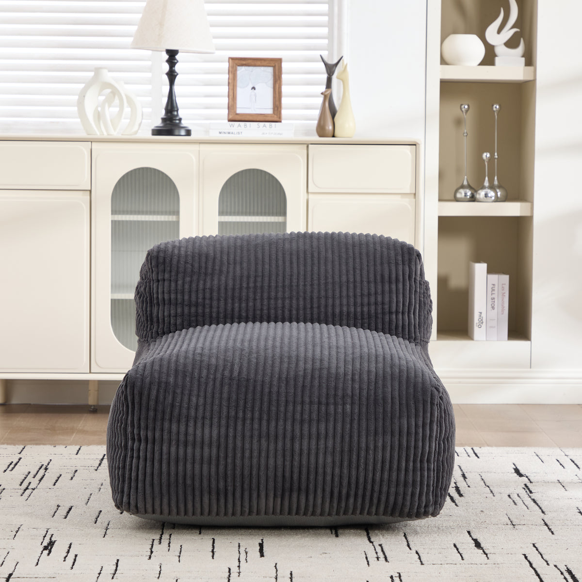 Dark gray corduroy bean bag chair on a pale wooden floor