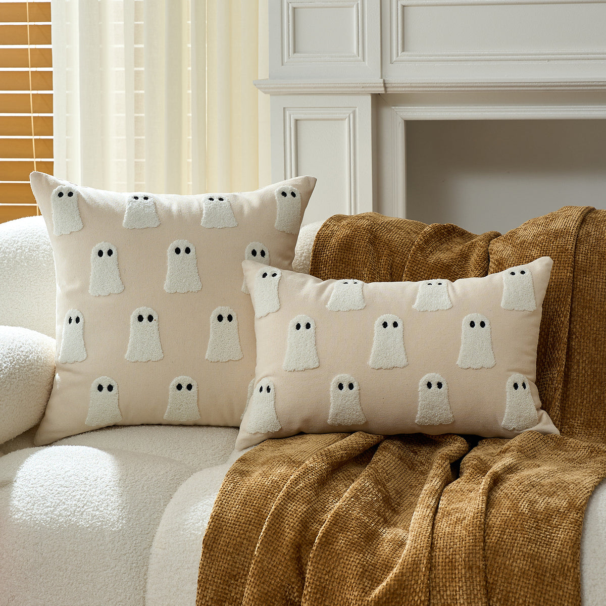 Pair of mini ghost print cushion covers on a cream sofa