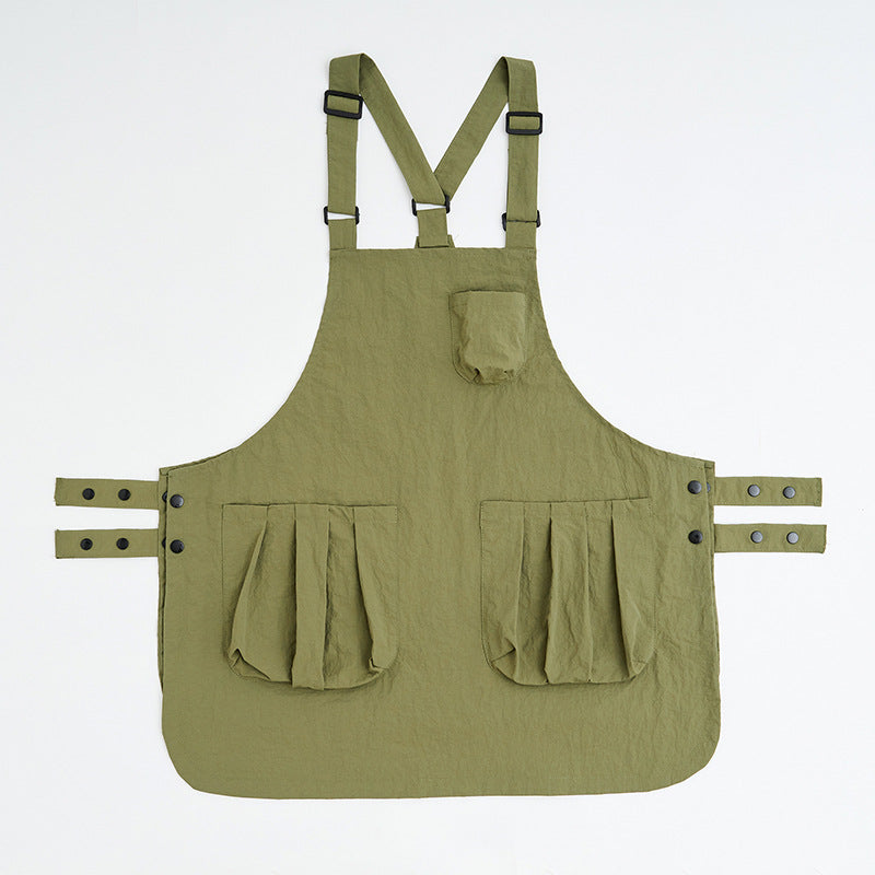 Army green kitchen apron shown flat with twin front pockets