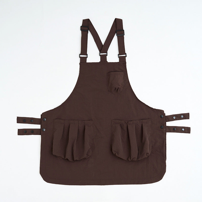 Dark coffee brown kitchen apron laid flat with cross-back straps