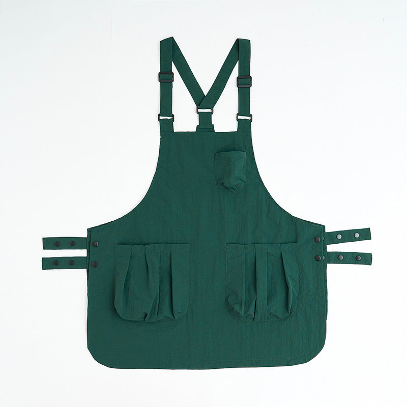 Deep green sleeveless kitchen apron with adjustable ties and pockets