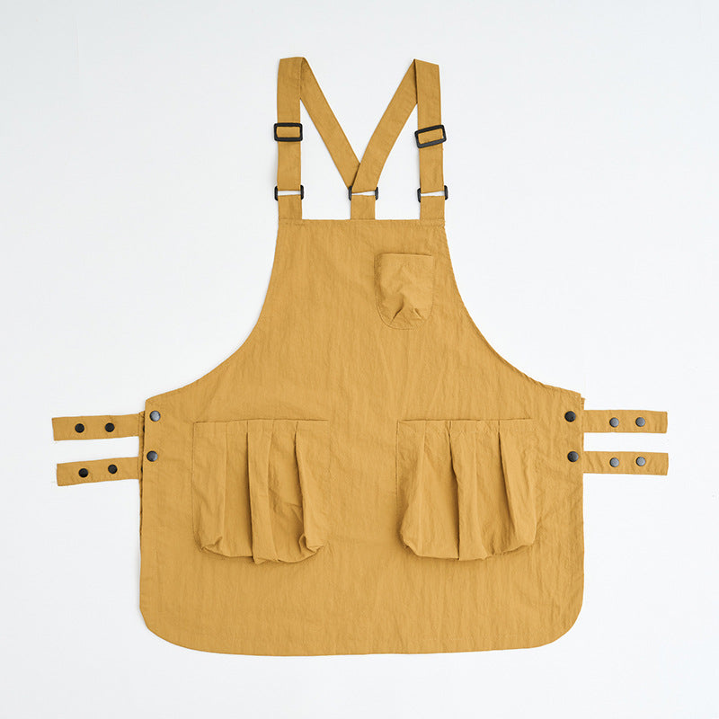 Mustard yellow kitchen apron with cross-back straps and front pockets