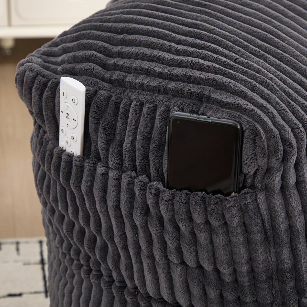 Phone tucked into the side pocket of the corduroy bean bag chair