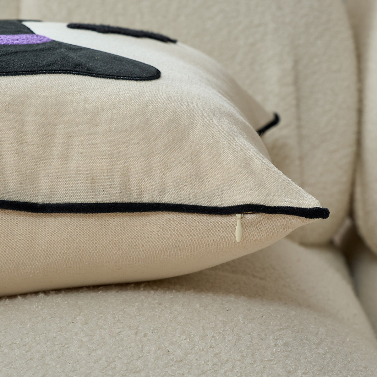 Close-up of the cream cushion cover piped edge and tufted texture