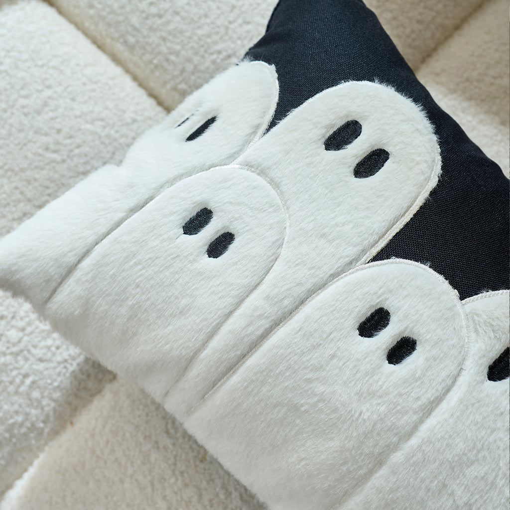 Close-up of three white tufted ghosts on a phantom cushion cover