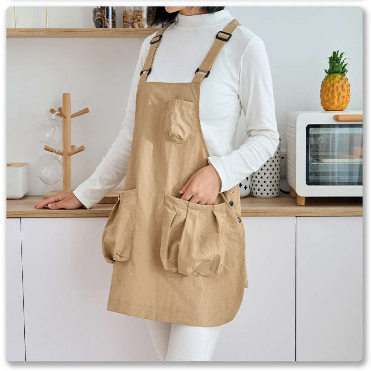 Woman in a khaki kitchen apron working at a home kitchen counter