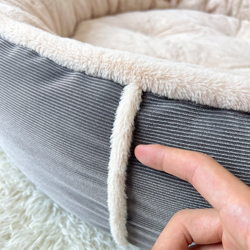 Hand pressing the padded rim of the round pet bed