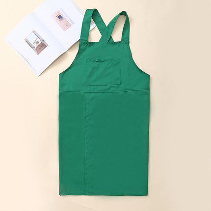 Green Korean style cross-back kitchen apron displayed flat against a wall