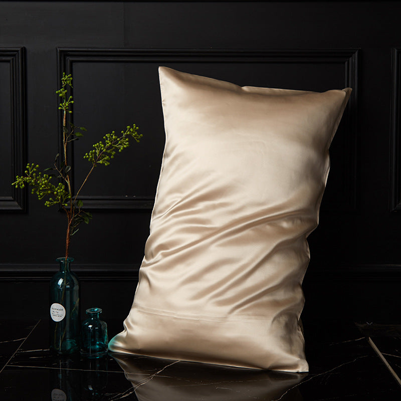 Champagne gold mulberry silk pillowcase with envelope closure on black marble surface