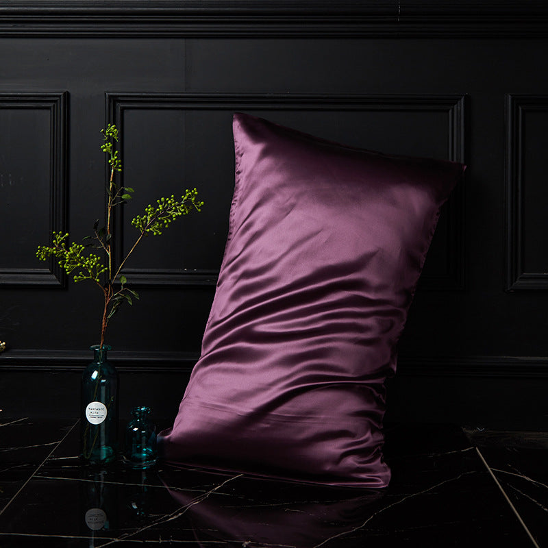 Glamorous purple mulberry silk envelope pillowcase draped softly on dark marble