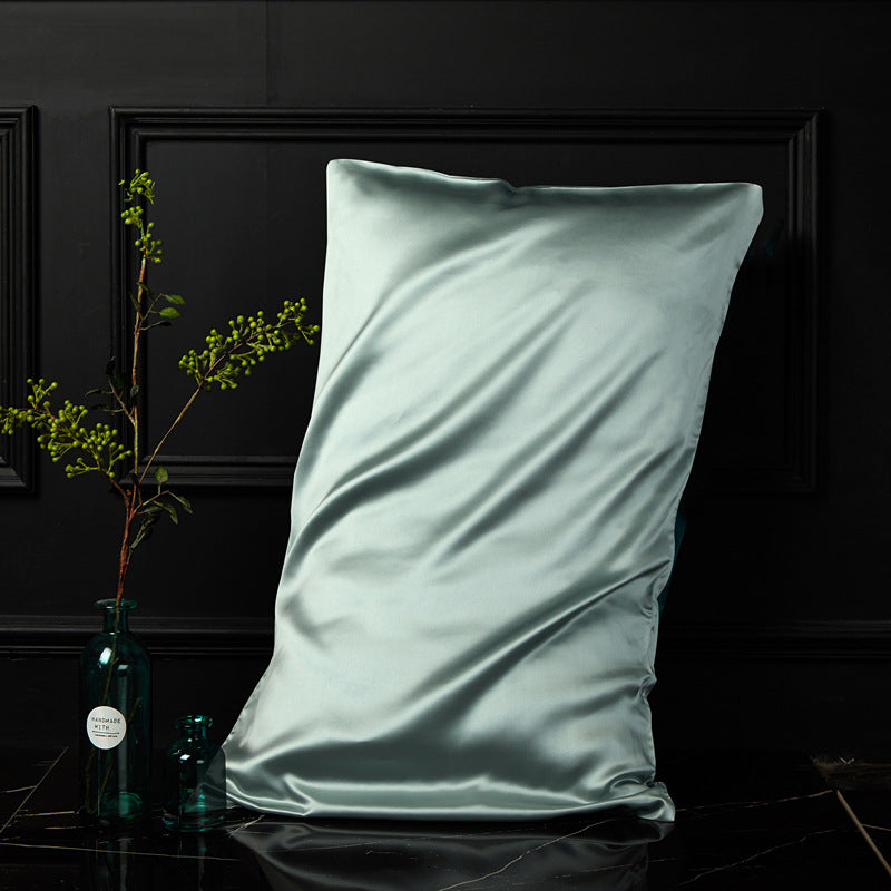 Matcha green mulberry silk envelope pillowcase in a calm dark bedroom setting
