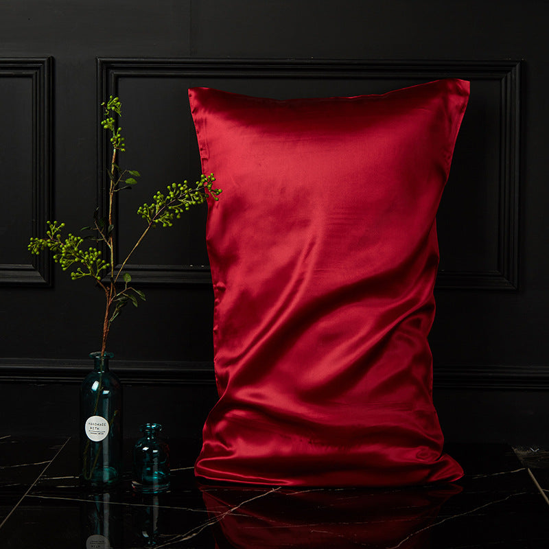 Romantic red mulberry silk envelope pillowcase glowing against a dark bedroom backdrop
