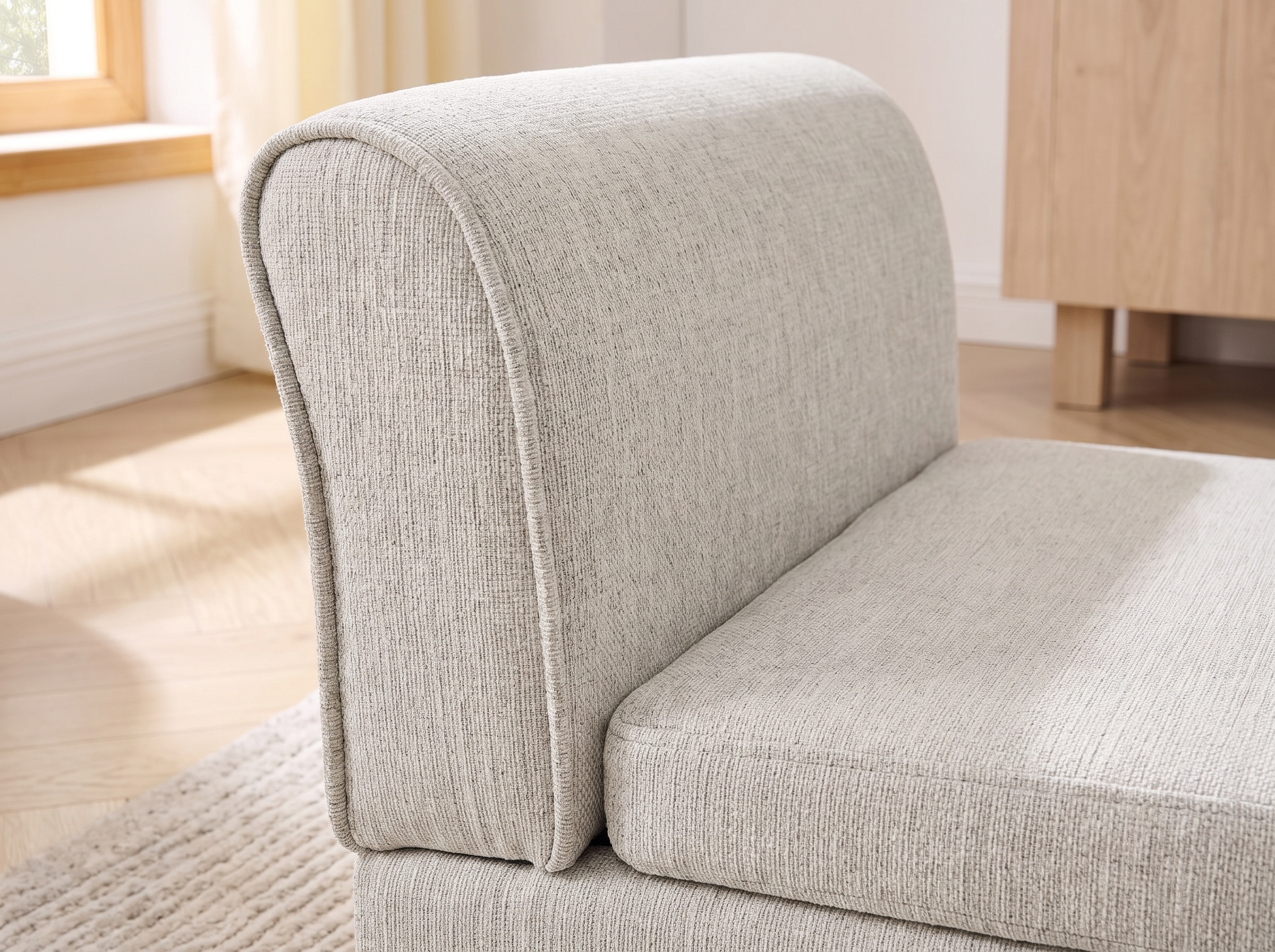 Close detail of the beige linen weave and piped edge of the pet sofa in soft daylight
